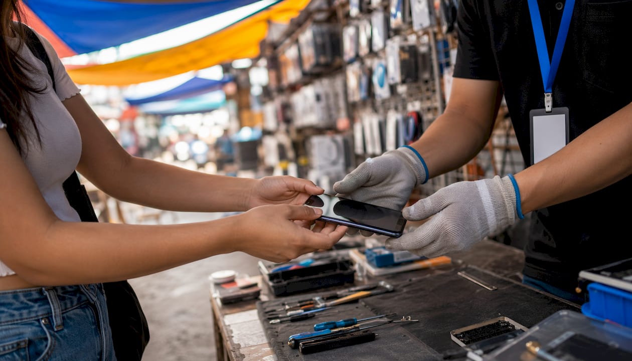Hands exchanging smartphone at repair counter
