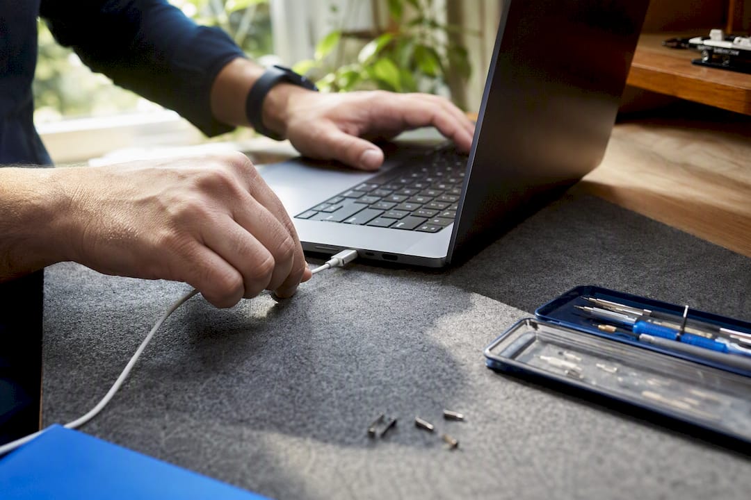 Technician hands repairing laptop charging port