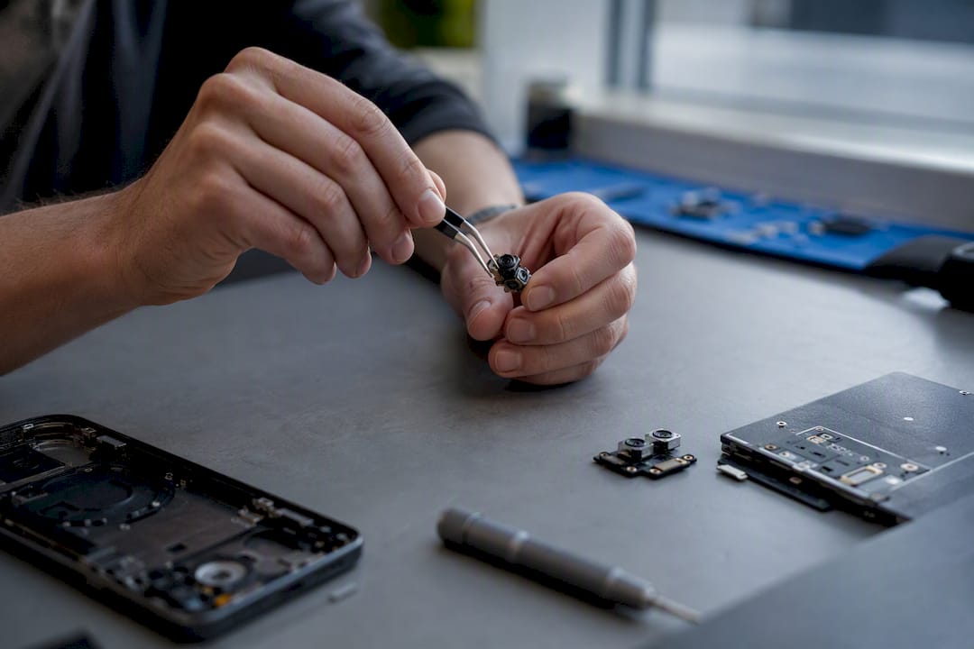 Technician handling small phone camera module