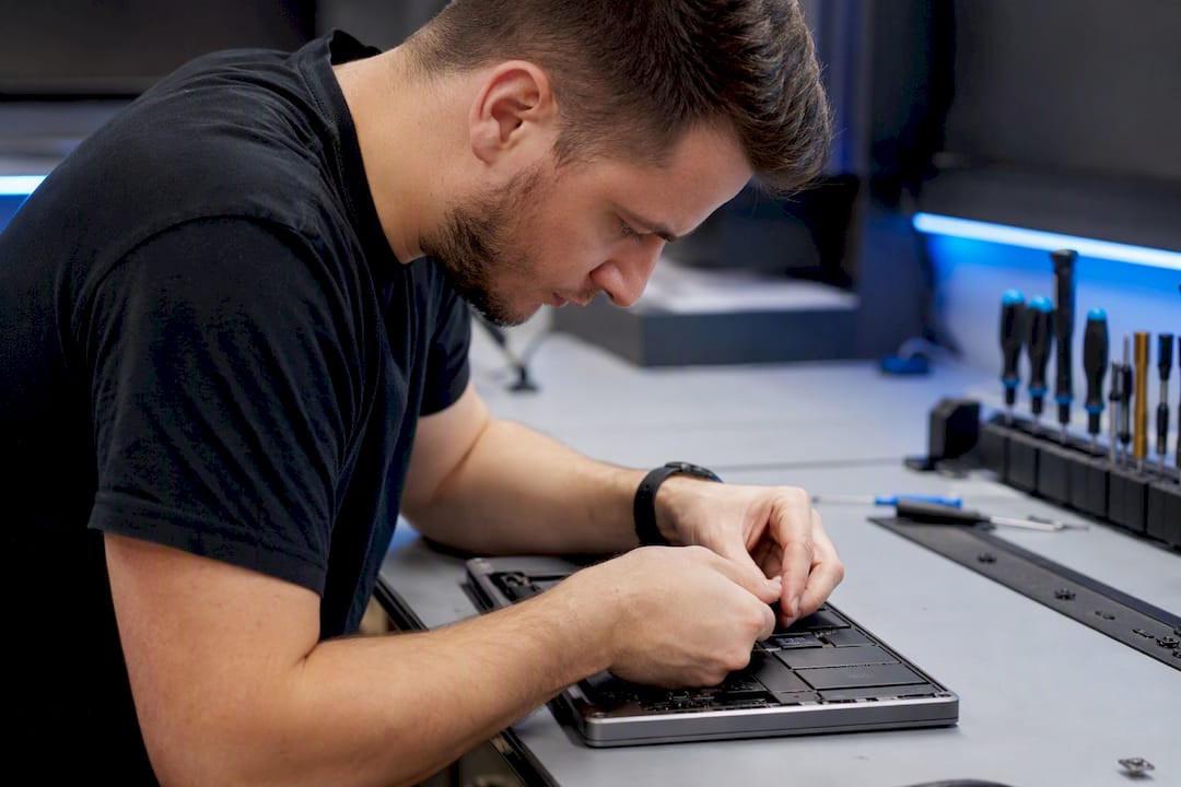 Hands inspecting laptop charging cable connection
