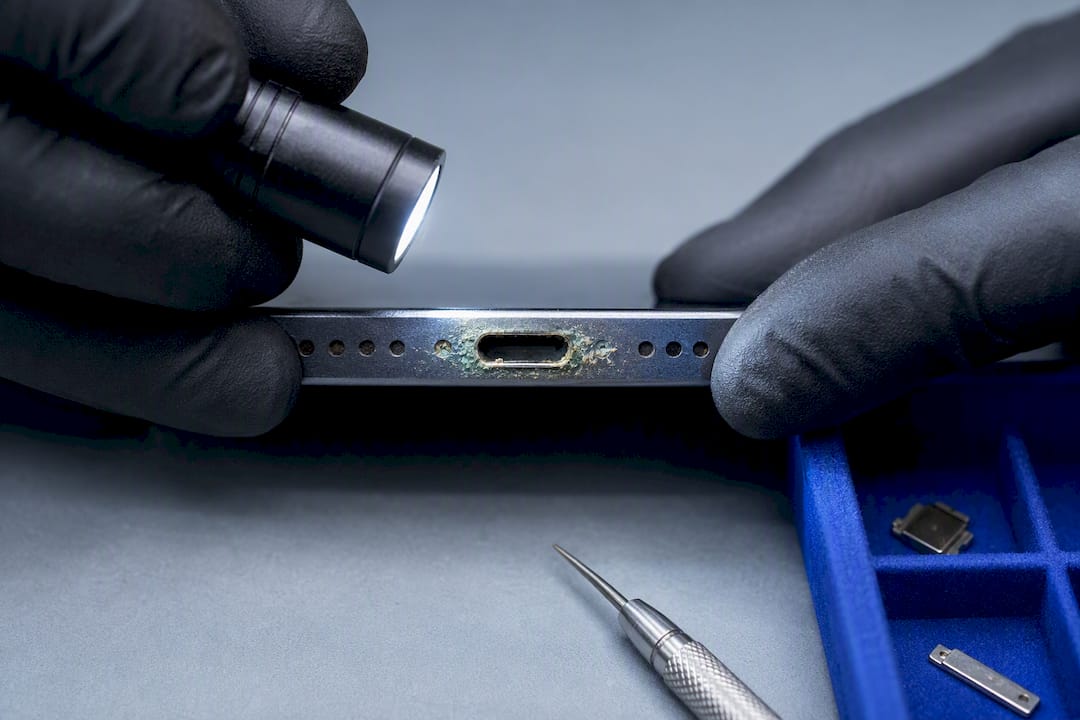 Technician inspecting corroded charging port