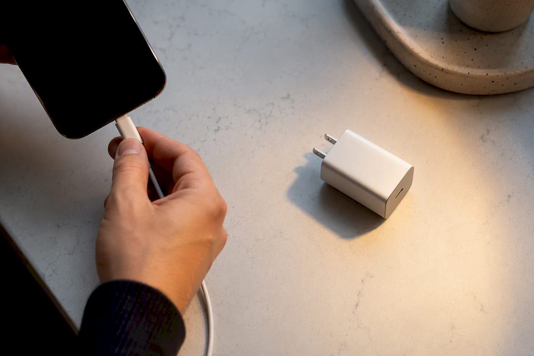 Hand connecting cable to phone charging setup