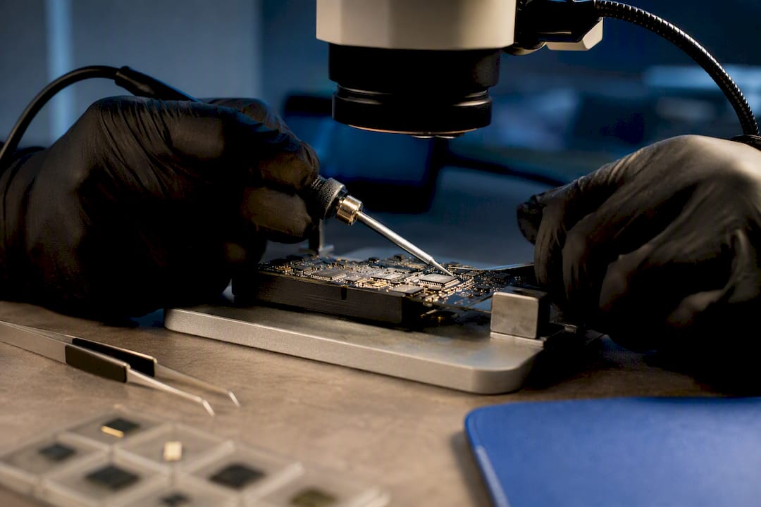 Technician soldering a circuit board under magnification