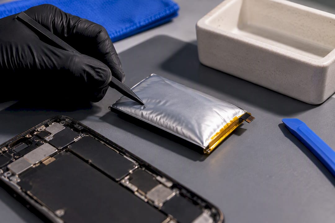 Technician inspecting a swollen phone battery