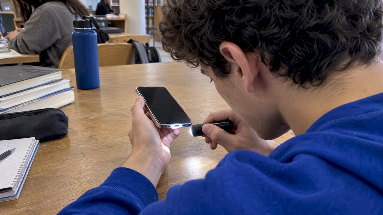 Student safely inspecting an iPhone charging port