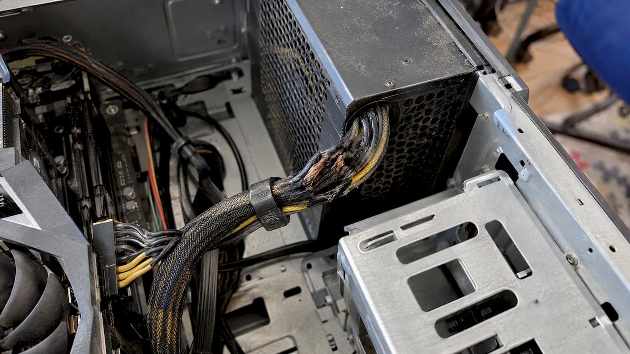 Scorched and frayed wiring beside a desktop PSU