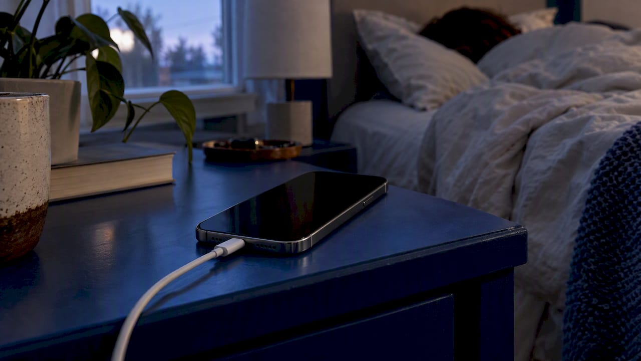 iPhone charging beside a bed overnight